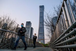 BEIJING, CHINA - APRIL 07: Chinese commuters wear protective masks as they cross a footbridge during rush hour in the central business district on April 7, 2020 in Beijing, China. China recorded for the first time since January 21st no coronavirus-related deaths. With the pandemic hitting hard across the world, officially the number of coronavirus cases in China is dwindling, ever since the government imposed sweeping measures to keep the disease from spreading. For more than two months, millions of people across China have been restricted in how they move from their homes, while other cities have been locked down in ways that appeared severe at the time but are now being replicated in other countries trying to contain the virus. Officials believe the worst appears to be over in China, though there are concerns of another wave of infections as the government attempts to reboot the worlds second largest economy. In Beijing, it is mandatory to wear masks outdoors, some retail stores still operate on reduced hours, restaurants employ social distancing among patrons, and tourist attractions at risk of drawing large crowds remain closed or allow only limited access. Monitoring and enforcement of virus-related measures and the quarantine of anyone arriving to Beijing is carried out by neighborhood committees and a network of Communist Party volunteers who wear red arm bands. Since January, China has recorded more than 81,000 cases of COVID-19 and at least 3200 deaths, mostly in and around the city of Wuhan, in central Hubei province, where the outbreak first started. (Photo by Kevin Frayer/Getty Images)